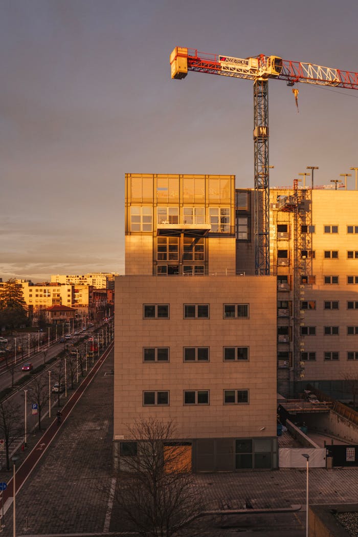 A cityscape view featuring buildings and a crane during sunset, highlighting urban development.